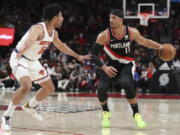 New York Knicks guard Quentin Grimes guards against Portland Trail Blazers forward Josh Hart during the first half of an NBA basketball game in Portland, Ore., Saturday, Feb. 12, 2022.