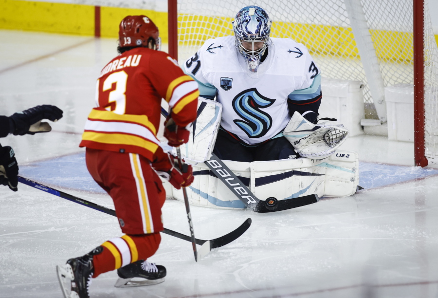 Seattle Kraken goalie Philipp Grubauer blocks a shot from Calgary Flames' Johnny Gaudreau during the second period of an NHL hockey game Saturday, Feb. 19, 2022, in Calgary, Alberta.