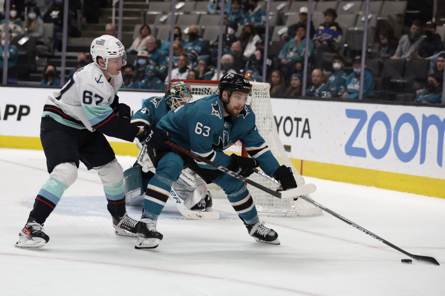 Seattle Kraken center Morgan Geekie (67) battles for the puck against San Jose Sharks left wing Jeffrey Viel (63) in the second period of an NHL hockey game in San Jose, Calif., Sunday, Feb. 27, 2022.