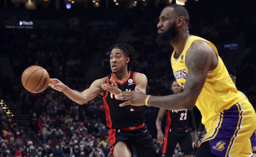 Portland Trail Blazers forward Trendon Watford, left, passes the ball as Los Angeles Lakers forward LeBron James, right, defends during the first half of an NBA basketball game in Portland, Ore., Wednesday, Feb. 9, 2022.