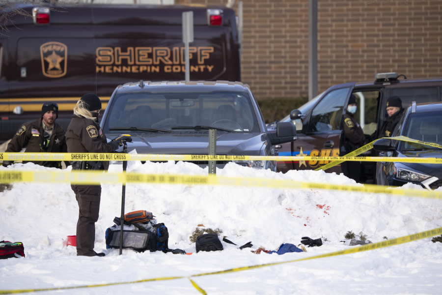 Investigators from Hennepin County Sheriff's Office process the scene of a shooting, Tuesday, Feb. 1, 2022, at the South Education Center, an alternative school in Richfield, Minn. Two students were shot, one of them fatally, outside the suburban Minneapolis school.