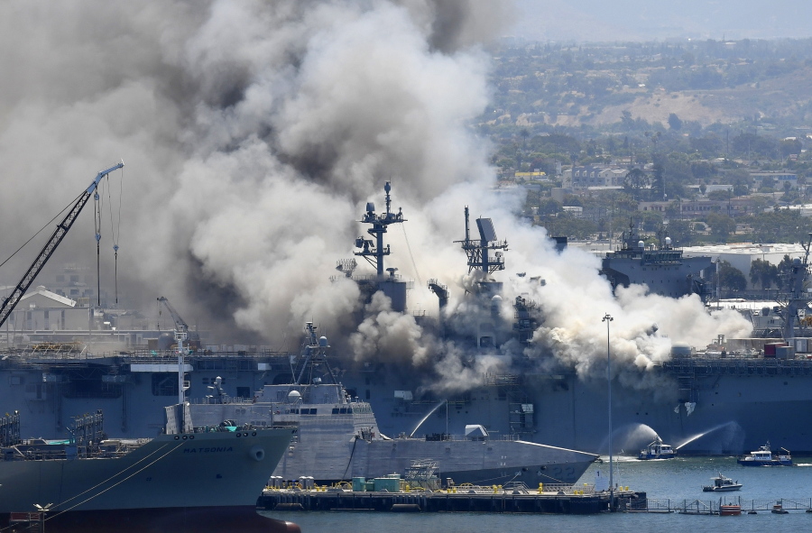 FILE - In this July 12, 2020, file photo, smoke rises from the USS Bonhomme Richard at Naval Base San Diego in San Diego, after an explosion and fire on board the ship at Naval Base San Diego. A sailor accused of starting the fire that destroyed the USS Bonhomme Richard will face a court martial for arson. The Navy notified Ryan Mays on Friday, Feb. 25, 2022, that he was to be tried in military court on two counts for the July 2020 blaze that injured dozens of personnel aboard.