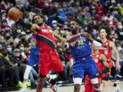 Portland Trail Blazers forward Greg Brown III, left, reaches for the ball in front of Denver Nuggets forward Jeff Green on Sunday in Portland.