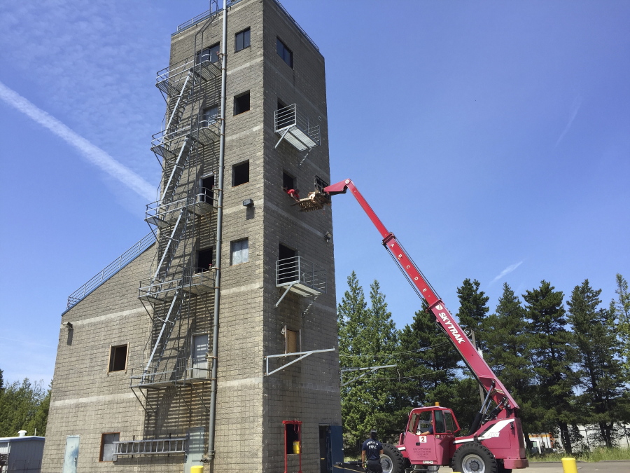 FILE - Portland Fire Department training recruits use a forklift to hoist dummies to the top of a six-story tower for a simulated rescue for tsunami and earthquake drill in Oregon and Washington state in Portland, Ore., June 7, 2016.  More than 90% of Oregon,??s liquid fuels are stored at a facility next to the Willamette River in Portland. Oregon lawmakers began taking steps to compel the owners and operators of aging storage tanks at the facility to make them earthquake resistant.