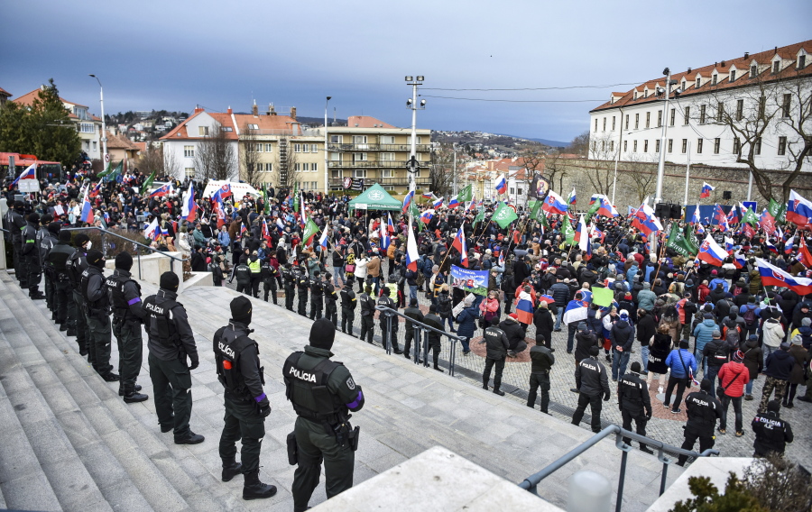 Thousands of Slovaks rally to protest a defense military treaty between this NATO member and the United States, in Bratislava, Slovakia, Tuesday, Feb. 8, 2022. Waving national flags, the protesters gathered in front of the Parliament that was debating the Defense Cooperation Agreement.