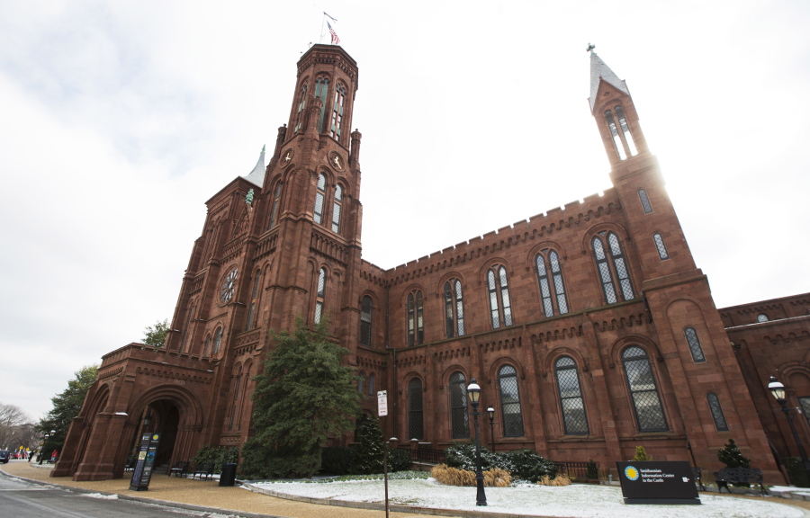 FILE - The Smithsonian Institution's Smithsonian Castle is seen at the National Mall in Washington, Jan. 27, 2015. The Smithsonian will commemorate Women's History Month in March 2022 by displaying 120 3D-printed statues depicting women who have excelled in the fields of science and technology. The life-size neon orange statues will be displayed in the Smithsonian Gardens and in select museums in the Smithsonian network in March.