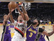 Portland Trail Blazers forward Norman Powell, center, shoots as Los Angeles Lakers guard Malik Monk, left, and forward Anthony Davis defend during the first half of an NBA basketball game Wednesday, Feb. 2, 2022, in Los Angeles. (AP Photo/Mark J.