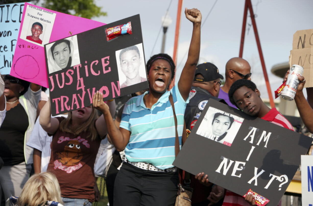 In this March 22, 2012 file photo, protestors, Lakesha Hall, of Sanford, center, and her son, Calvin Simms, right, participate in a rally for Trayvon Martin, the black teenager who was fatally shot by George Zimmerman, a neighborhood watch captain in Sanford, Fla. The killing of Trayvon Martin at the hands of a stranger still reverberates 10 years later -- in protest, in partisanship, in racial reckoning and reactionary response, in social justice and social media.
