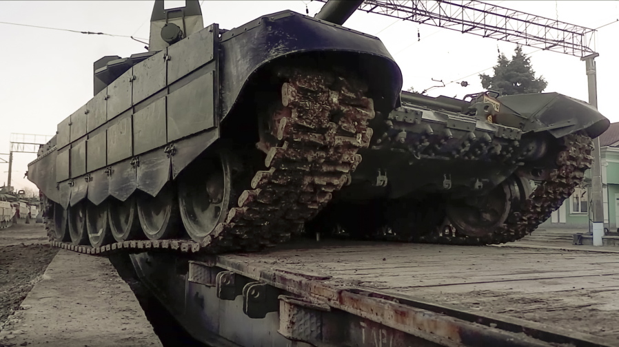 In this photo taken from video provided by the Russian Defense Ministry Press Service on Tuesday, Feb. 15, 2022, A Russian tank is loaded onto railway platforms after the end of military drills in South Russia. In what could be another sign that the Kremlin would like to lower the temperature, Russia's Defense Ministry announced Tuesday that some units participating in military exercises would begin returning to their bases.