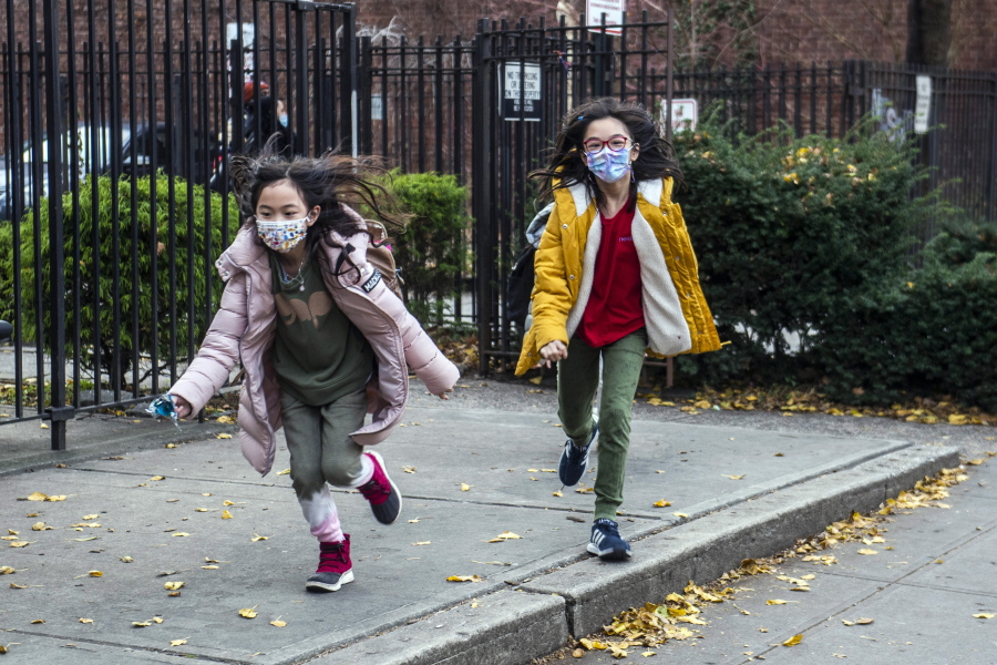 FILE -- Students wearing masks leave the New Explorations into Science, Technology and Math (NEST+m) school in the Lower East Side neighborhood of Manhattan, Dec. 21, 2021, in New York. New York City public school students will be allowed to remove their masks outside starting next week but must keep them on indoors for now. Schools Chancellor David Banks announced the new policy in a news release Friday, Feb. 25, 2022.