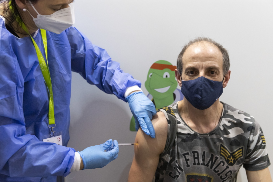 A person gets vaccinated against the COVID-19 virus as the compulsory COVID-19 vaccination starts in Vienna, Austria, Friday, Feb. 4, 2022.