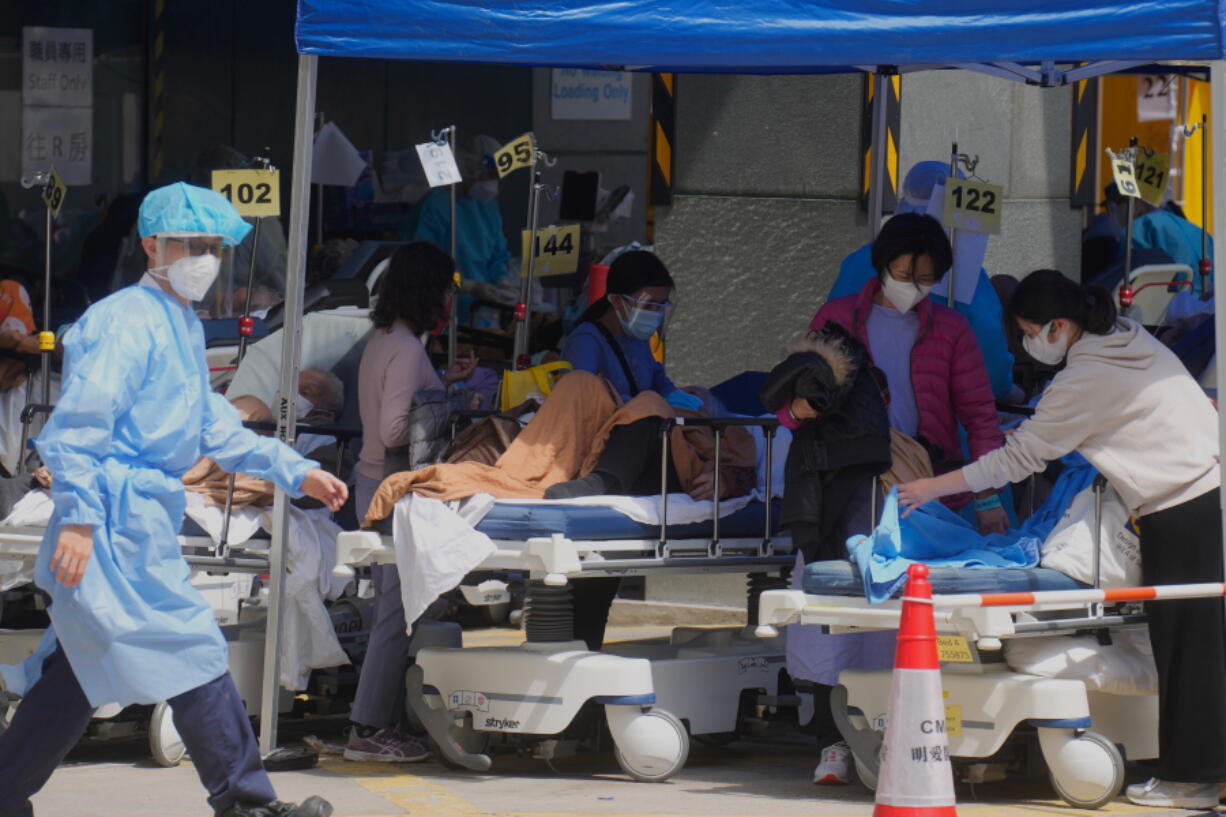 Patients in hospital beds wait at temporary holding area outside Caritas Medical Centre in Hong Kong, Monday, Feb. 28, 2022.
