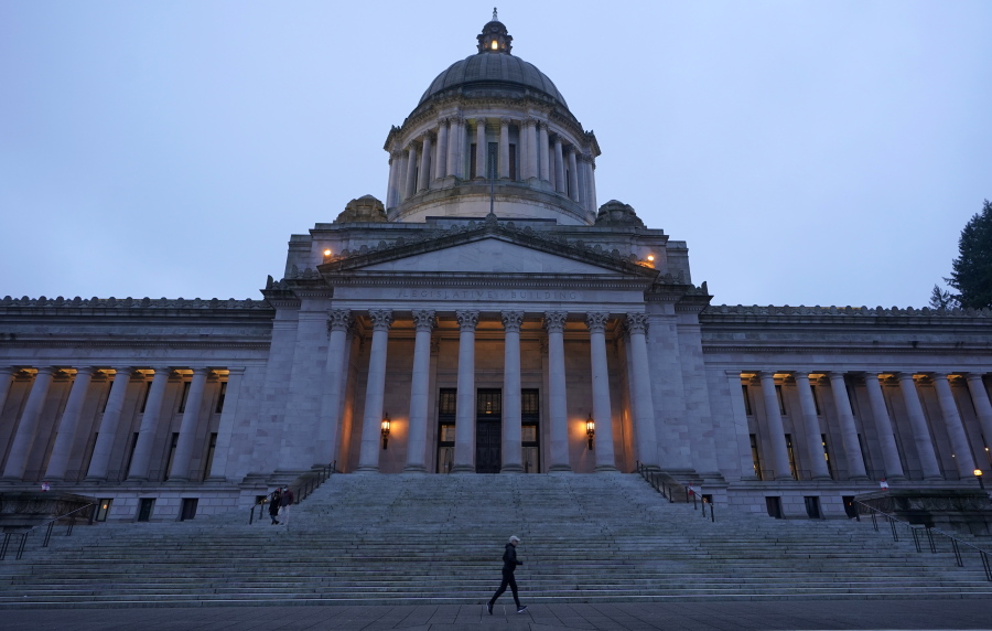 A jogger runs past the Legislative building just before dusk on Dec. 21 at the Capitol in Olympia.