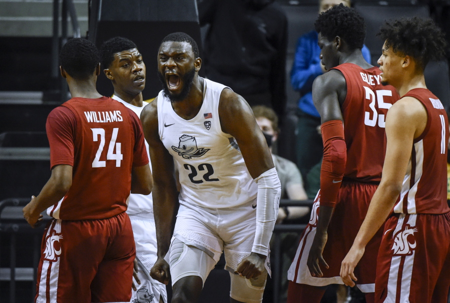 Oregon center Franck Kepnang (22) reacts after making basket and being fouled, as Oregon forward Eric Williams Jr. (50) stands at left and Washington State guard Noah Williams (24), forward Mouhamed Gueye (35) and forward DJ Rodman (11) watch during the second half of an NCAA college basketball game Monday, Feb. 14, 2022, in Eugene, Ore.