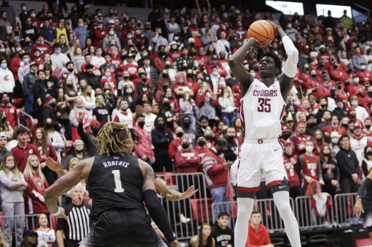 Washington State forward Mouhamed Gueye (35) shoots as Washington forward Nate Roberts (1) watches during the second half of an NCAA college basketball game, Wednesday, Feb. 23, 2022, in Pullman, Wash. Washington State won 78-70.