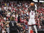 Washington State forward Mouhamed Gueye (35) shoots as Washington forward Nate Roberts (1) watches during the second half of an NCAA college basketball game, Wednesday, Feb. 23, 2022, in Pullman, Wash. Washington State won 78-70.