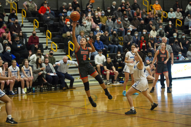 Washougal guard Chloe Johnson (0) takes a shot in the lane as Hockinson’s Delaney Chappelle looks on during Washougal’s 56-43 win over the Hawks in a 2A girls basketball district winner-to-state game.