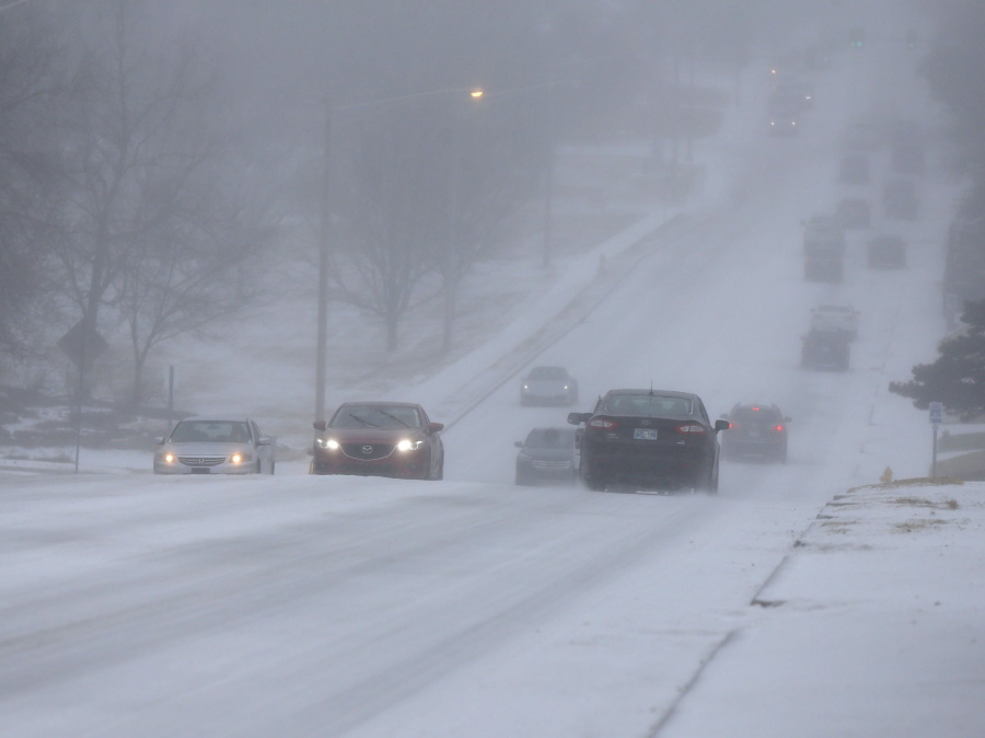 Motorists drive during a sleet storm in Tulsa, Okla,, Wednesday, Feb. 23, 2022.