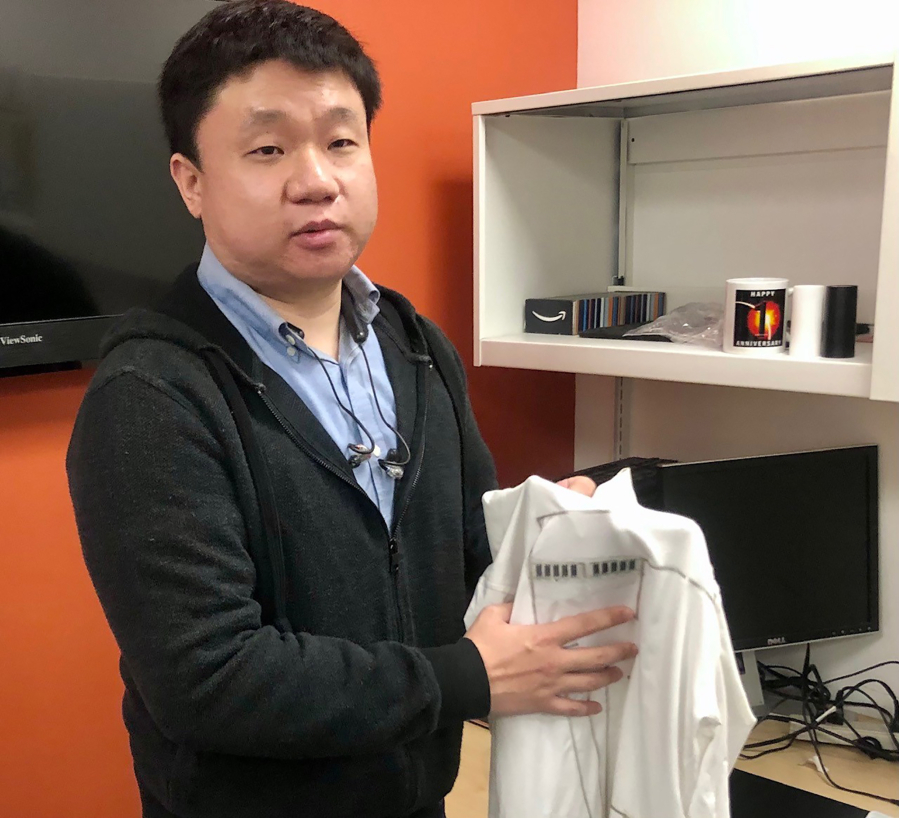 Yu Lin, a UC San Diego Ph. D. student at the Jacobs School of Engineering, holds what researches have dubbed a "wearable microgrid" that can harvest and store energy while the wearer moves or exercises.