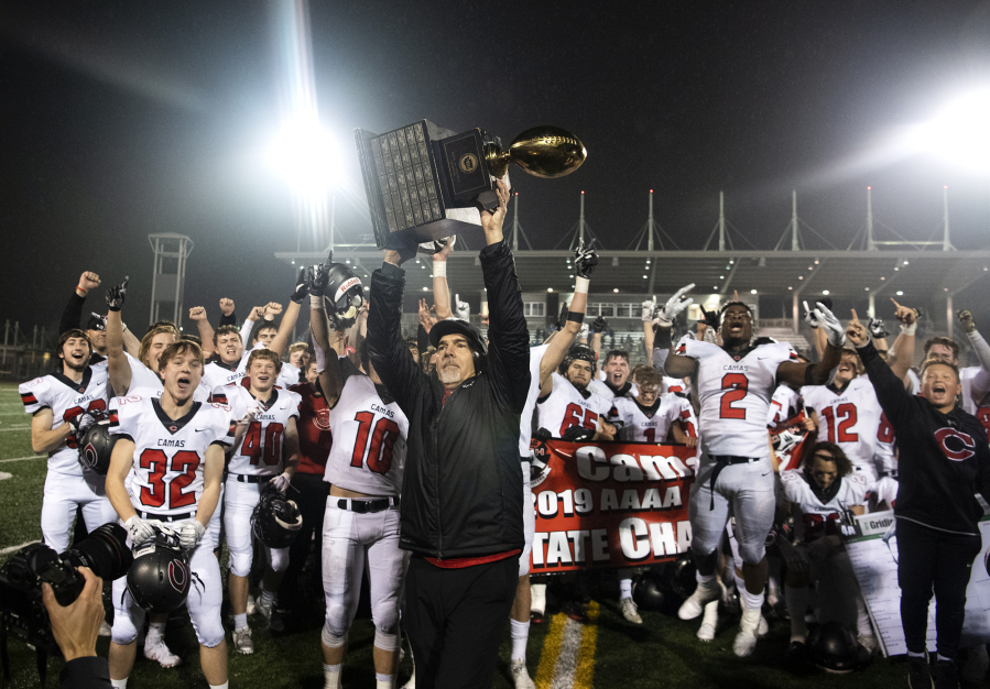 Camas head coach Jon Eagle hoists the trophy into the air after Saturday?s win in the Class 4A state championship game against Bothell at Mount Tahoma High School in Tacoma on Dec. 7, 2019.