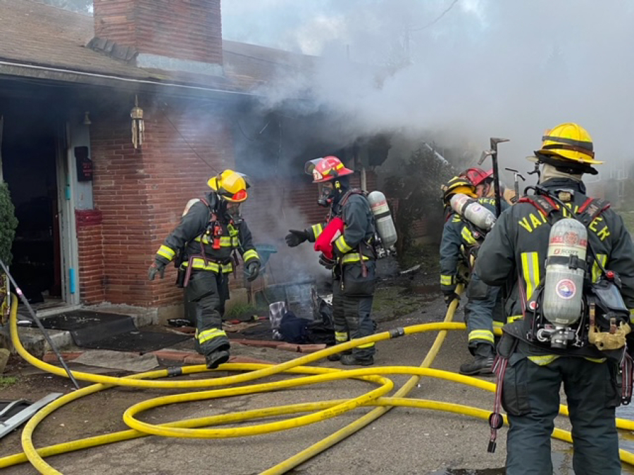 Vancouver Fire Department firefighters extinguish an apartment fire Friday morning in Vancouver's Rose Village neighborhood. One man was taken to a Portland burn center with serious injuries.