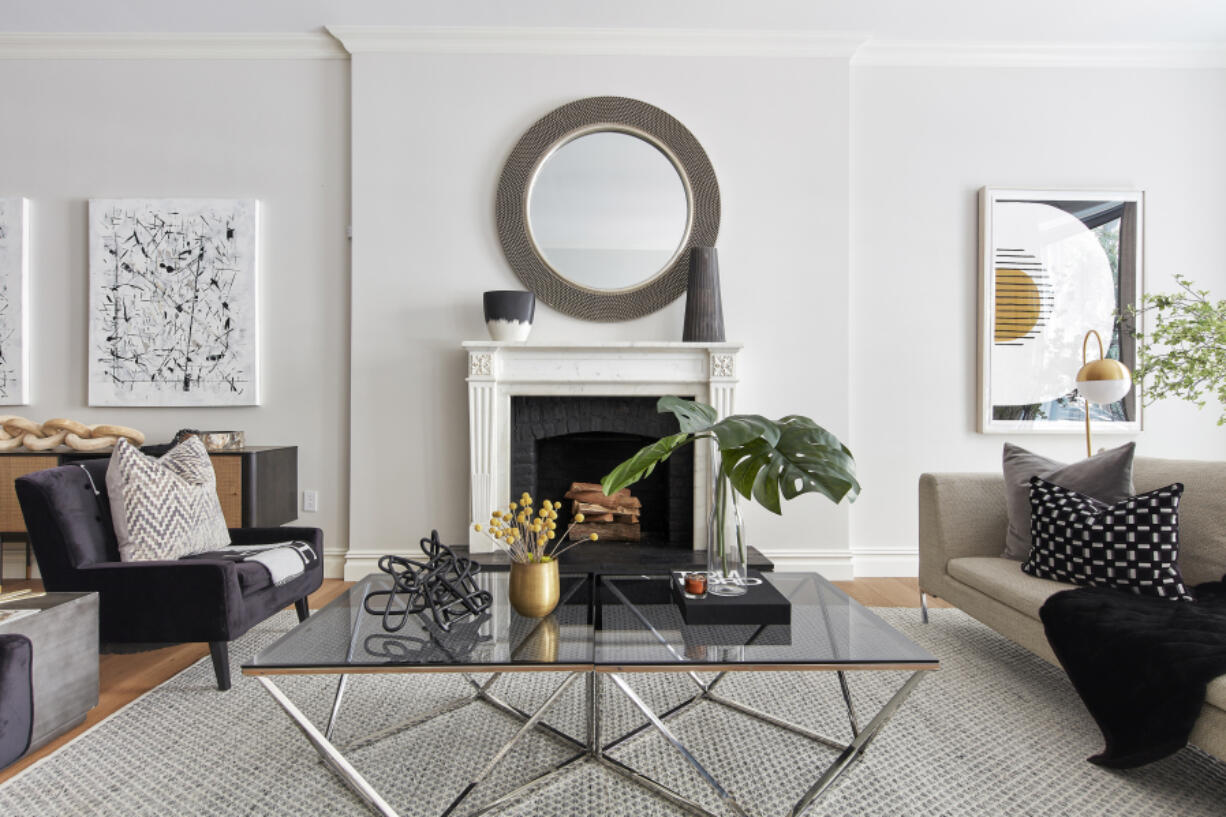 An oversized round mirror helps to anchor the fireplace in this space.