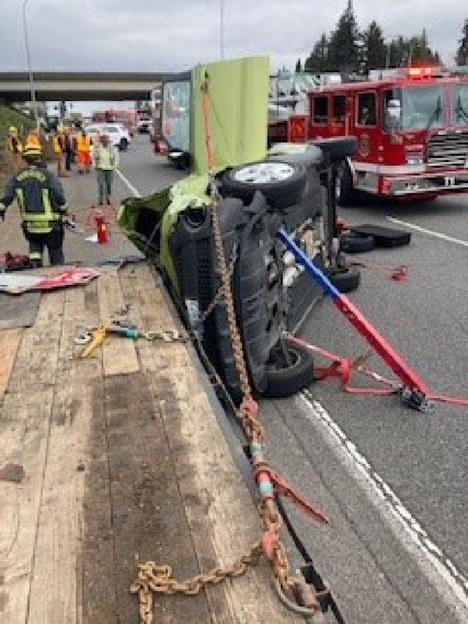 The car a 72-year-old Vancouver woman was extricated from after she crashed into an Oregon woman changing lanes Wednesday morning southbound on Interstate 5. The Vancouver woman's Kia Soul slid into a flatbed trailer that road crews were using on the shoulder of the freeway.