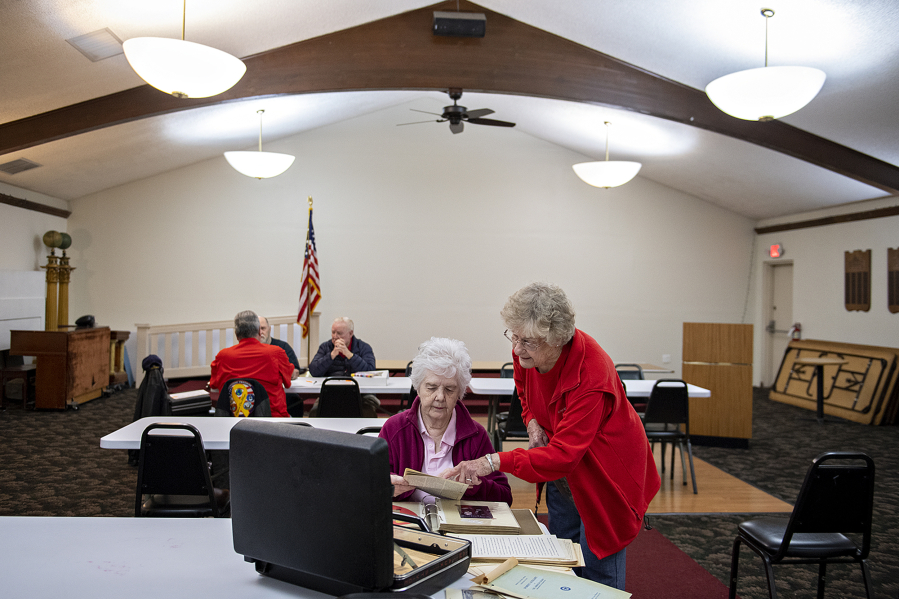 Kate Sharp, left, and Janet Easley of American Legion Auxiliary Unit 14 select historical photos and documents for their upcoming celebration at American Legion Post 14 on Friday morning. American Legion Auxiliary Unit 14's centennial anniversary was postponed for a year due to challenges posed by COVID-19. This year, it partnered with the Clark County Historical Society to digitize a portion of its records, which it will be presenting at the event today.