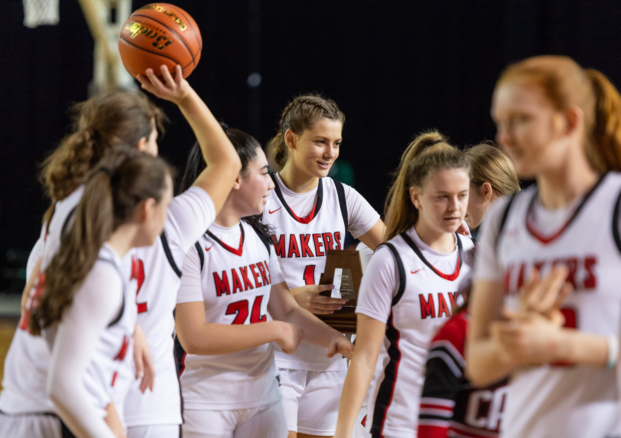 Camas' Reagan Jamison cradles a fourth-place trophy as the Papermakers exit the court after a 4A State Girls Basketball fourth-place game on  Saturday, March 5, 2022, at the Tacoma Dome.
