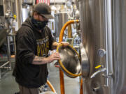 Brewer Josh McKinley installs a gasket into a fermentation tank at 54-40 Brewing Co. in Washougal. The brewery has been picked up for statewide distribution.