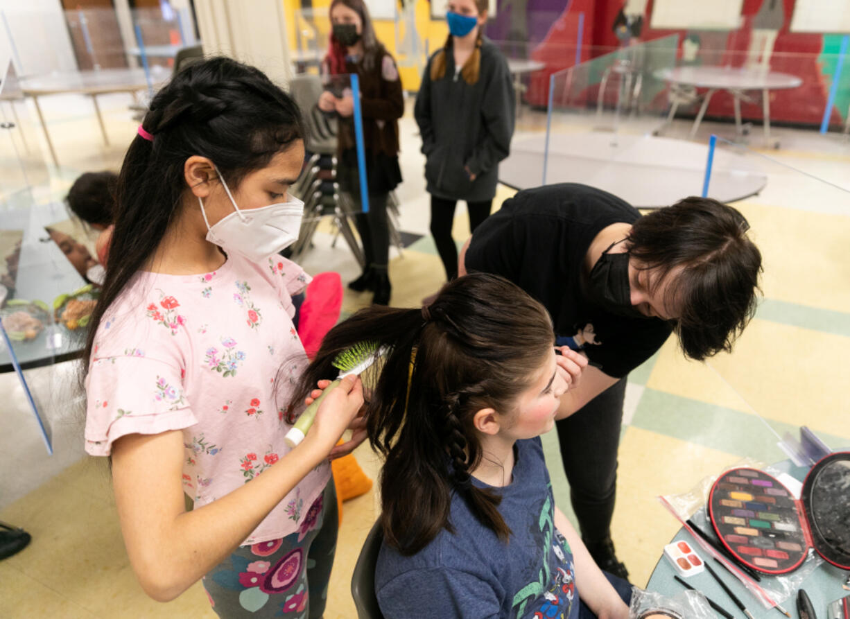 Naivy Phan 12, left, and Gloria Galland, 18, help Kai Shook, 17, all of Vancouver, with the finishing touches of their hair and makeup before the school's opening night production of "A Midsummer Night's Dream" at Vancouver School of Arts and Academics on March 10.