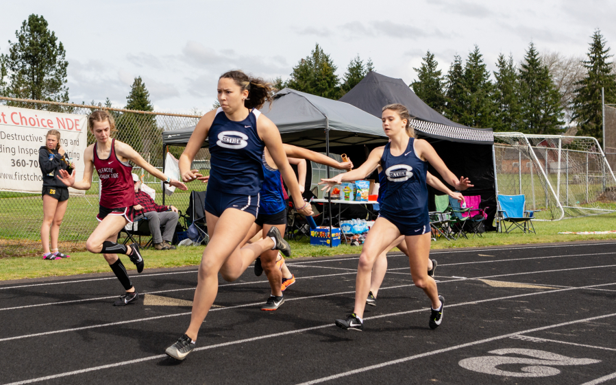 Skyview's Cecelia Fox-Middleton takes the baton from Bailey Boyd in the girls' 4x100 relay at the Tiger Invite on Saturday at Battle Ground High School. Skyview finished second to Camas in the event. For more photos from Saturday visit 360preps.com.