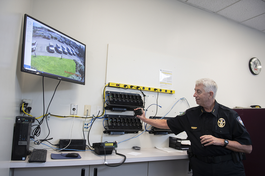 Camas Police Chief Mitch Lackey looks over a body camera at the charging station Thursday afternoon at the Camas Police Department. The department is beginning officer training in the new body-worn camera program.