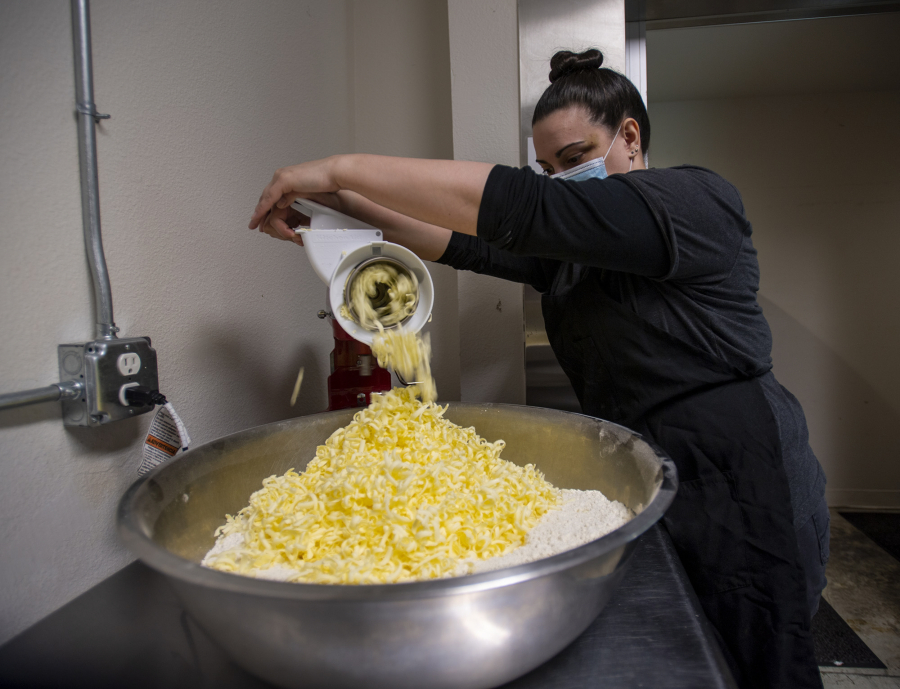 Lead baker Jesi Aradoz shreds butter into a large bowl for scones at River Maiden Coffee. A global butter shortage is causing problems for commercial bakers.