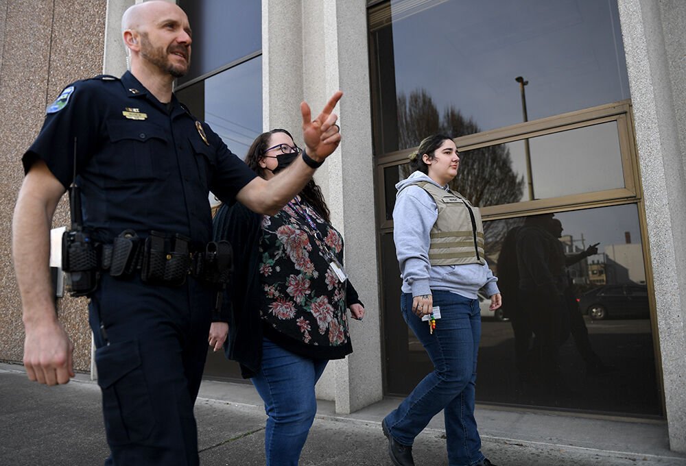 Longview Police Capt. Branden McNew, left, Columbia Wellness Chief Clinical Officer Kathy Ryan and Longview Police Behavioral Health Unit member River Phillips walk down Hudson Street Friday in front of the Longview Police Department headquarters.