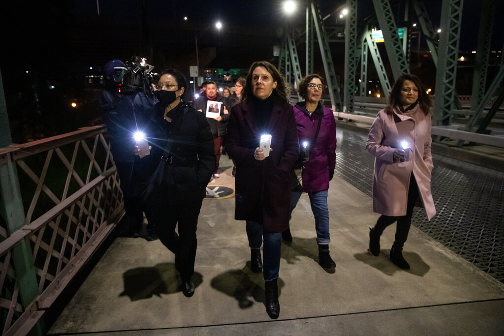 In a photo provided by Multnomah County, Multnomah County Chair Deborah Kafoury, center, leads the illuminated walk over the Hawthorne Bridge with Commissioners Lori Stegmann, left, Jessica Vega Pederson, second from right, and Susheela Jayapal, right, Thursday, March 10, 2022, in Portland, Ore., during an event held two years after the first confirmed case of COVID-19 in Portland.