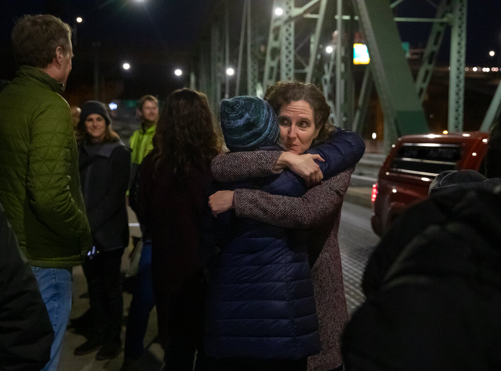 In a photo provided by Multnomah County, Dr. Jennifer Vines, lead regional health officer for the Portland metro area, hugs a county employee after moment of silence Thursday, March 10, 2022, in Portland, Ore., during an event marking two years since the first case of COVID-19 was confirmed in Portland.