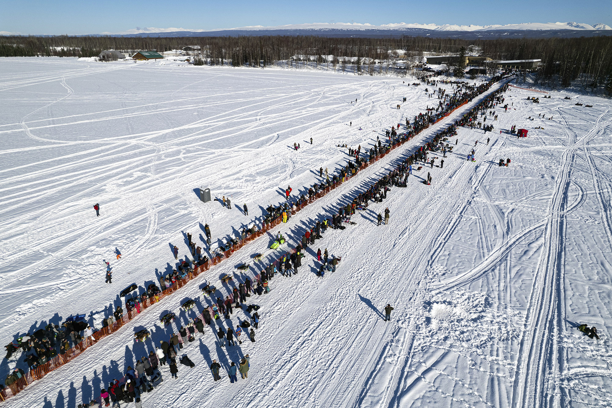 A competitor mushes across Willow Lake during the restart of the Iditarod Trail Sled Dog Race on March 6, 2022, in Willow, Alaska.