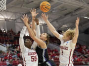 Washington State's Bella Murekatete (55) and Tara Wallack (1) battle for a rebound with Kansas State's Ayoka Lee, middle, during the first half of a college basketball game in the first round of the NCAA tournament in Raleigh, N.C., Saturday, March 19, 2022.