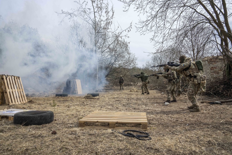 Ukrainian soldiers of the 103rd Separate Brigade of the Territorial Defense of the Armed Forces, fire their weapons, during a training exercise, at an undisclosed location, near Lviv, western Ukraine, Tuesday, March 29, 2022.