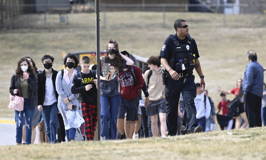Students from Olathe East High school are led off busses to reunite with their parents Friday, March 4, 2022, at Pioneer Trail Middle School in Olathe, Kan.,, after a shooting at the high school.  Authorities say a suspect shot and wounded a school resource officer and an administrator at the suburban Kansas City high school.  Police say a suspect has been taken into custody and there are no reports of injured students.