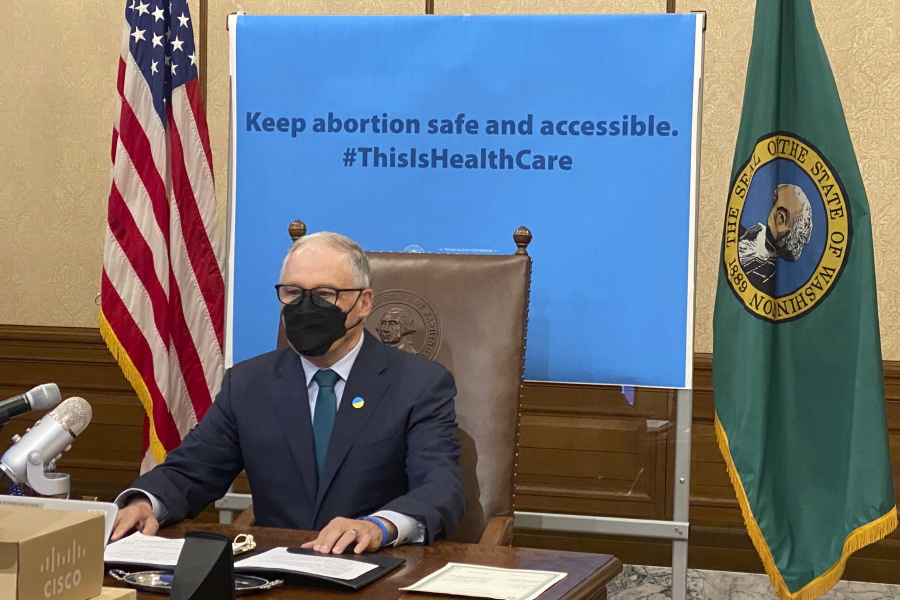 Washington Gov. Jay Inslee is seen before signing a measure that prohibits legal action against both people seeking an abortion and those who aid them, on Thursday, March 17, 2022, in Olympia, Wash. Inslee's signature comes days after the Legislature in neighboring Idaho approved a bill modeled on a law in Texas that allows lawsuits to enforce a ban on abortions performed after six weeks of pregnancy.