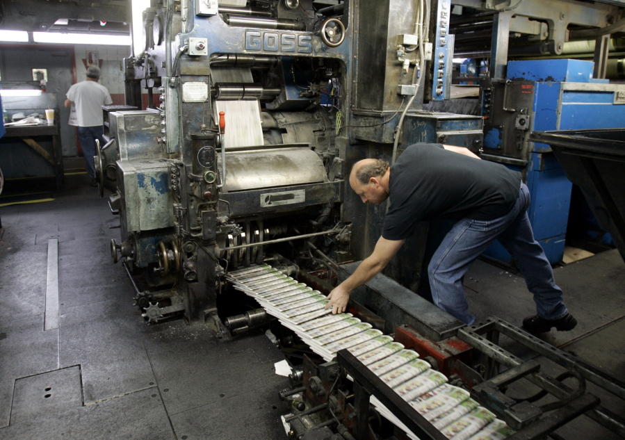 FILE - A pressman grabs a freshly printed paper off the press at the St. Louis Post-Dispatch's printing facility in Maryland Heights, Mo. in this Nov. 11, 2008 file photo. The Post-Dispatche's owner, Lee Enterprises efforts to repel a hostile takeover got a boost when a judge ruled the newspaper publisher could ignore two director nominations from the Alden Global Capital hedge fund. But Alden said it will press the fight by urging shareholders to reject two of Lee's nominees for the board.