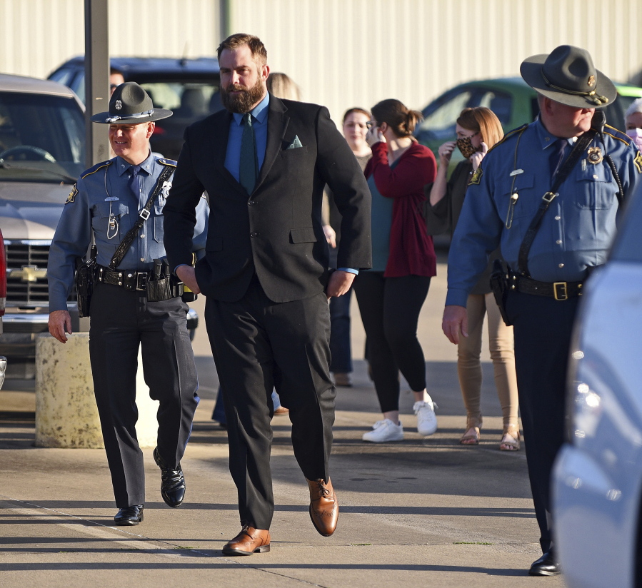 Arkansas State Troopers escort former Lonoke County sheriff's deputy Michael Davis into the Cabot Readiness Center on Thursday, March 17, 2022, for the third day of Davis's manslaughter trial in Cabot, Ark. Jurors began deliberating Thursday in the manslaughter trial of the former Arkansas deputy, who fatally shot Hunter Brittain, an unarmed 17-year-old, during a traffic stop.