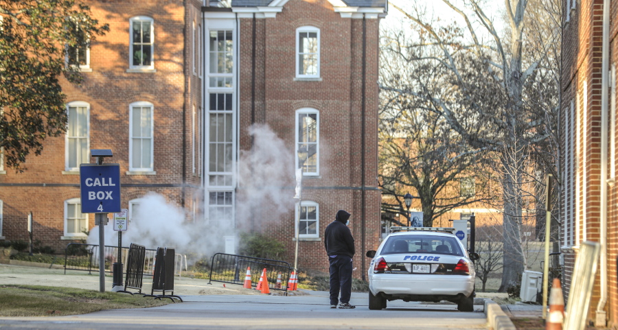 FILE - A man speaks with a police officer in a patrol vehicle outside the Spelman campus, Feb. 1, 2022. after two historically Black colleges in Georgia received bomb threats.  Vice President Kamala Harris is set to announce that historically Black colleges and universities, many of which recently received bomb threats, are eligible for federal campus security grants.