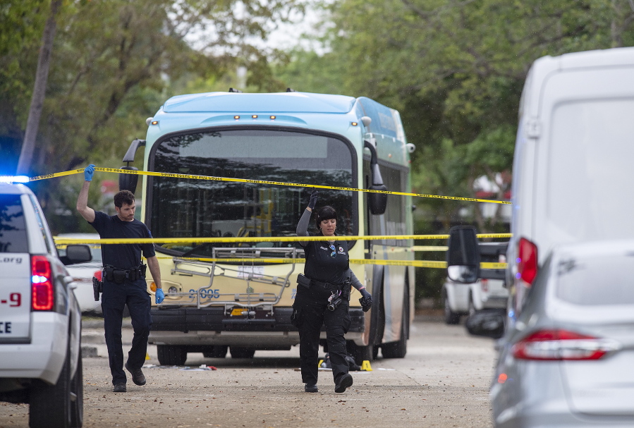 Law enforcement investigate at the scene of shooting on a Broward County Transit bus Thursday afternoon, March 17, 2022, in Fort Lauderdale, Fla. Officials say two people were killed and two others were wounded during a shooting on a South Florida commuter bus.