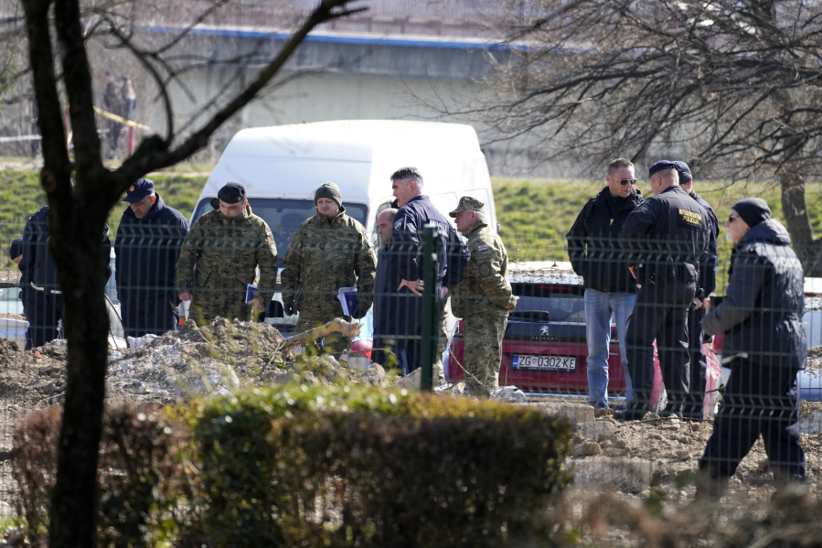 Police inspect site of a drone crash in Zagreb, Croatia, Friday, March 11, 2022. A drone that apparently flew all the way from the Ukrainian war zone crashed overnight on the outskirts of the Croatian capital, Zagreb, triggering a loud blast but causing no injuries, Croatian authorities said Friday.