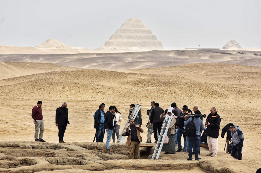 Reporters prepare to enter a recently discovered tomb near the famed Step Pyramid, in Saqqara, south of Cairo, Egypt, Saturday, March 19, 2022. Egypt on Saturday displayed a recently discovered, finely-decorated ancient tombs at an infamous Pharaonic necropolis just outside the capital of Cairo. The five tombs, unearthed earlier this month, date back to the Old Kingdom (1570 B.C. and 1069 B.C.) and the First Intermediate Period, an era spanned for around 125 years after the collapse of the old kingdom, according to the Ministry of Tourism and Antiquities.