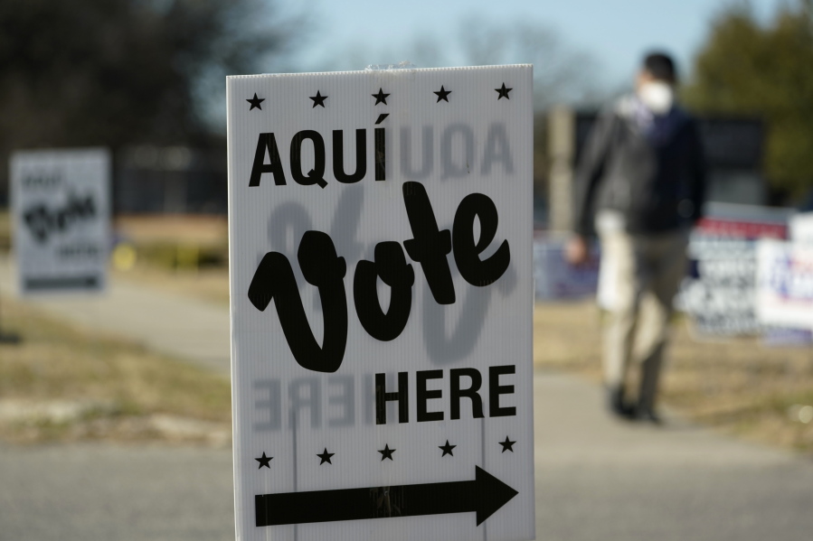 FILE - A man passes an early voting poll site, on Feb. 14, 2022, in San Antonio.