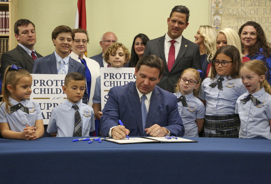 Florida Gov. Ron DeSantis signs the Parental Rights in Education bill at Classical Preparatory school Monday, March 28, 2022 in Shady Hills, Fla. (Douglas R.